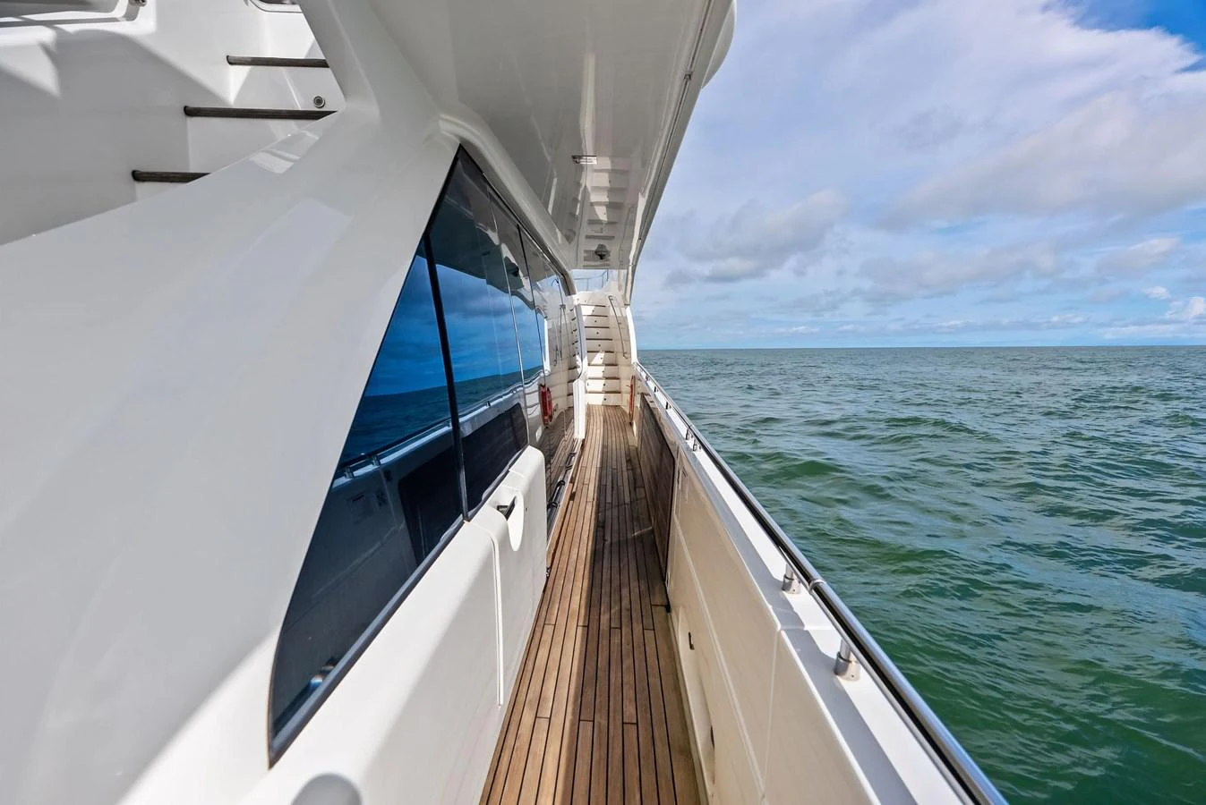 The yacht's side deck offers a spacious walkway with stunning ocean views. aboard SHA SHA SHA IV Yacht for Sale