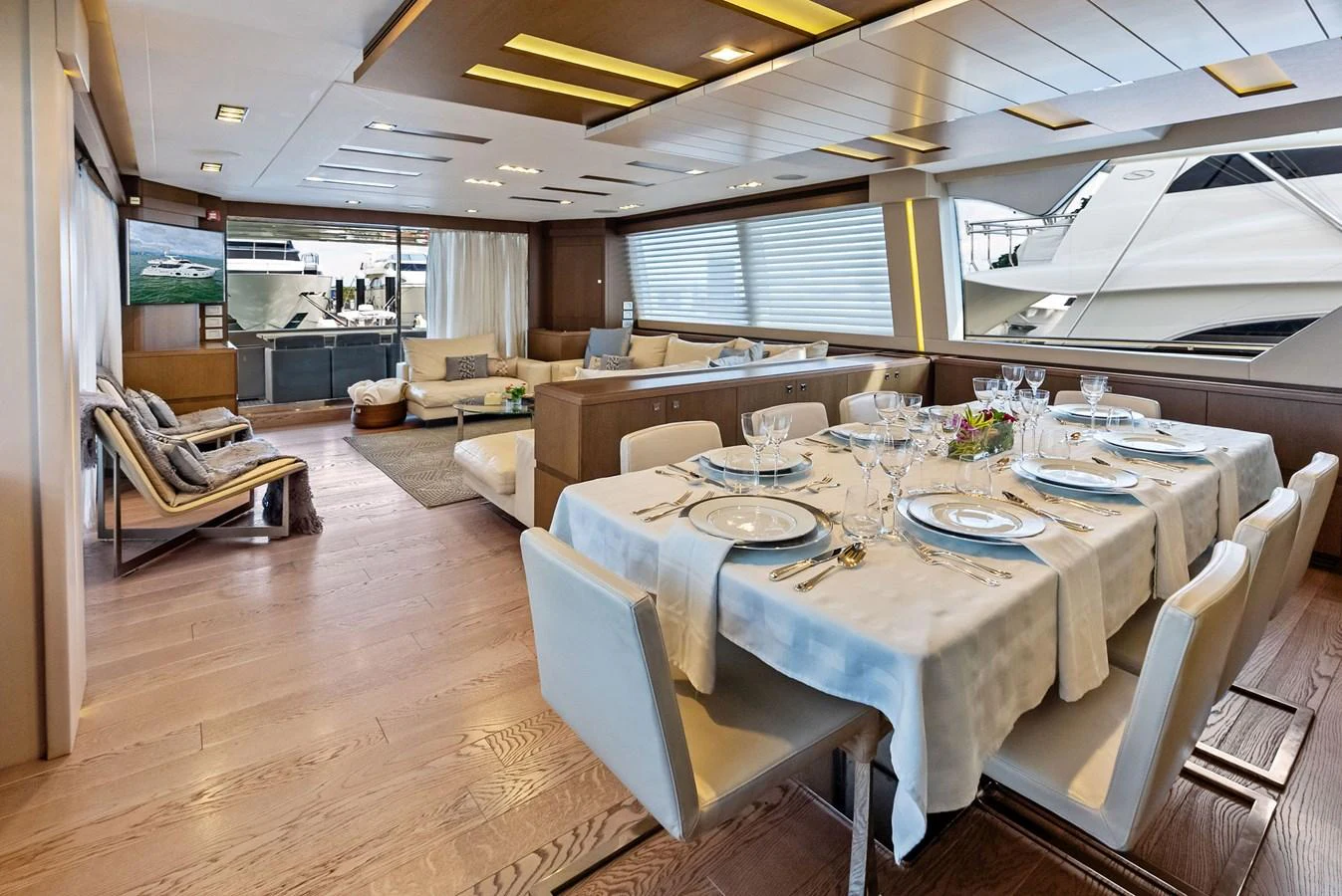 The yacht's dining area features an elegant table set for a meal, complemented by a spacious and stylish lounge area. aboard SHA SHA SHA IV Yacht for Sale