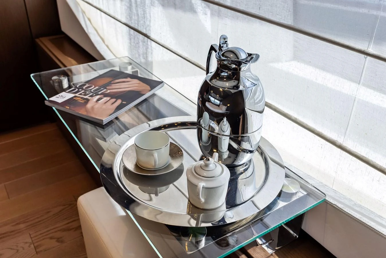 A stylish coffee set is elegantly arranged on a glass table, accompanied by a magazine. aboard SHA SHA SHA IV Yacht for Sale