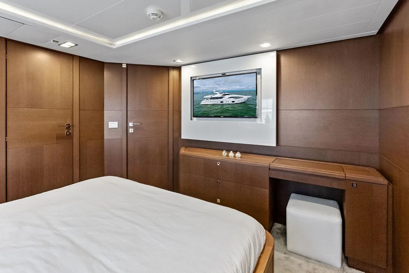 The stateroom features a sleek, modern design with a large bed and a wall-mounted TV. aboard SHA SHA SHA IV Yacht for Sale