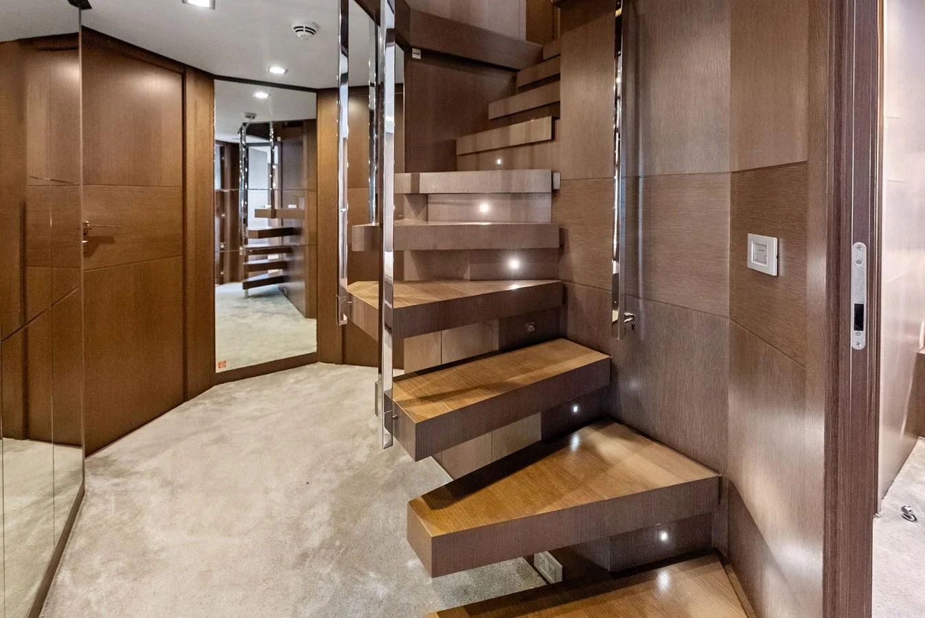 A modern wooden staircase with sleek design elements inside the yacht. aboard SHA SHA SHA IV Yacht for Sale