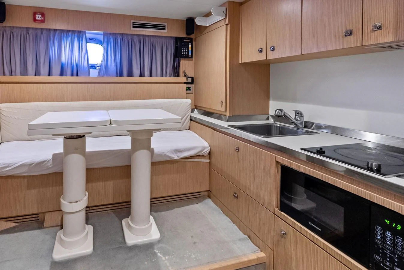 The galley features modern appliances and a cozy dining area with a convertible table. aboard SHA SHA SHA IV Yacht for Sale