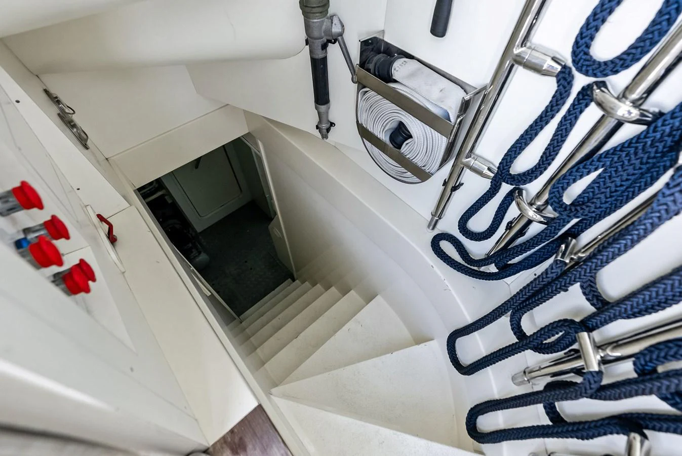 A staircase leads down to the lower deck, with neatly coiled ropes and equipment stored on the side. aboard SHA SHA SHA IV Yacht for Sale