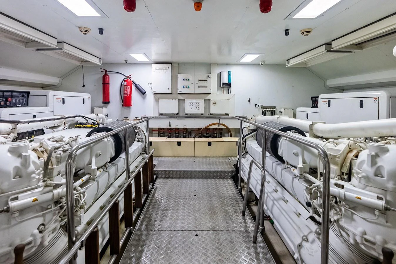 The engine room is meticulously organized, showcasing powerful machinery and essential safety equipment. aboard SHA SHA SHA IV Yacht for Sale