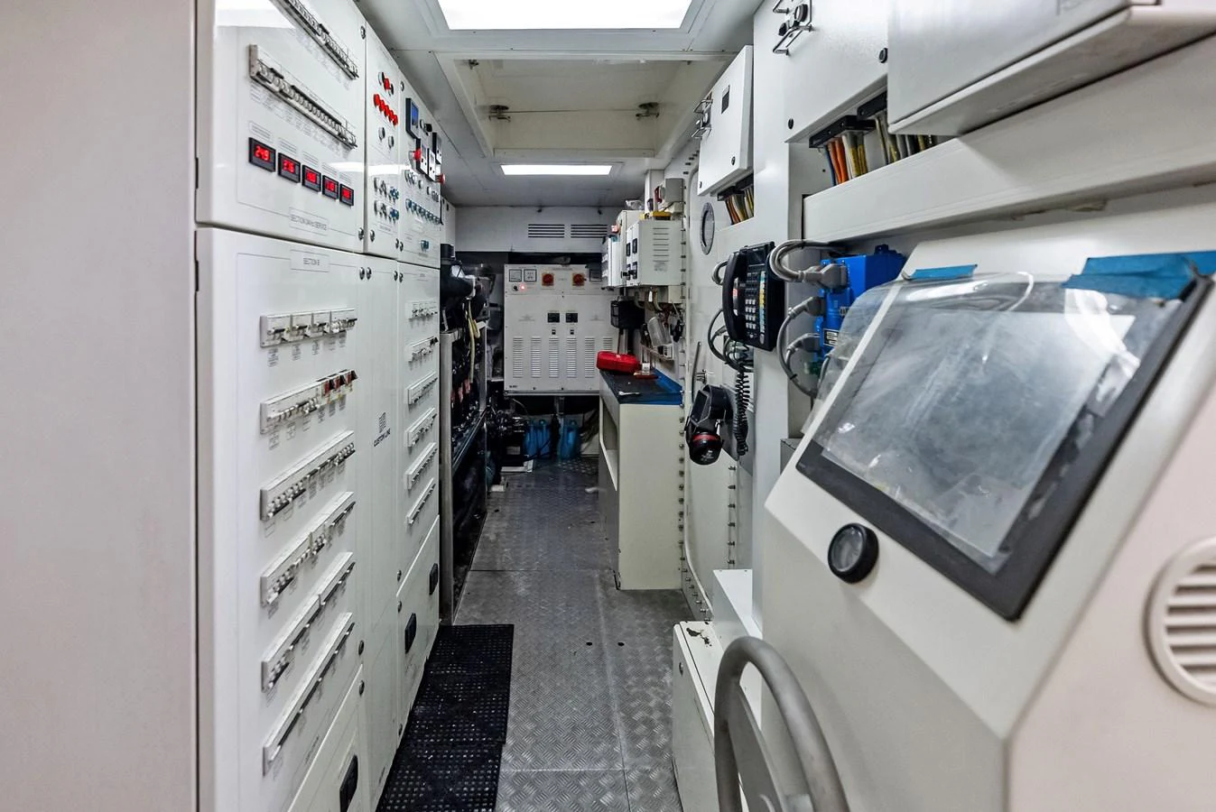The image showcases the yacht's well-equipped engine room with various control panels and machinery. aboard SHA SHA SHA IV Yacht for Sale