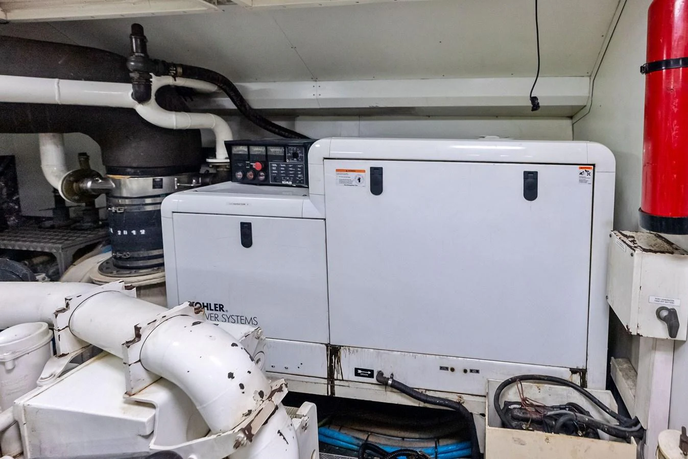 The image showcases the engine room with Kohler power systems and various mechanical components. aboard SHA SHA SHA IV Yacht for Sale