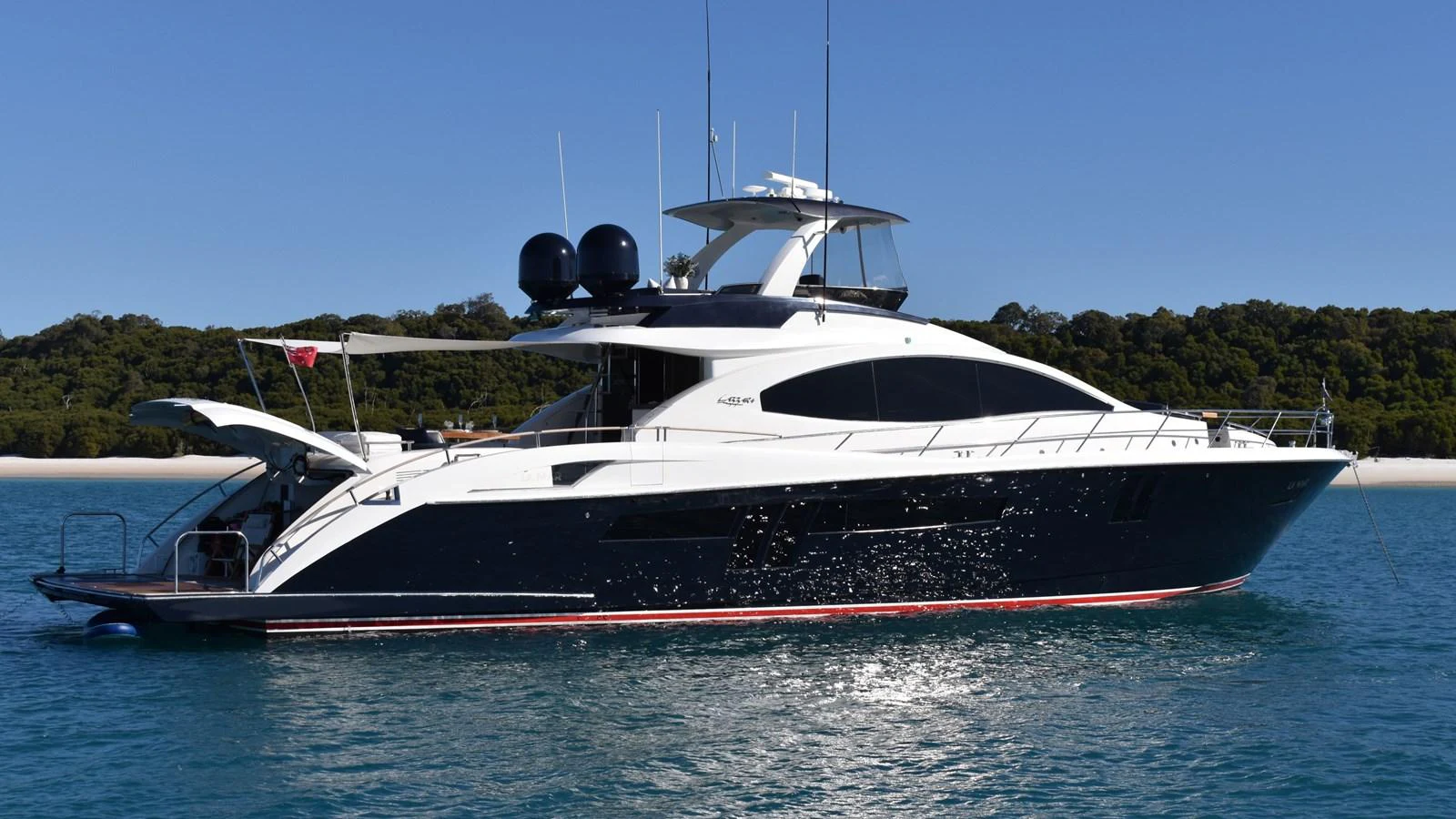A sleek and modern yacht is anchored in calm waters with a scenic backdrop. aboard LA MAR Yacht for Sale