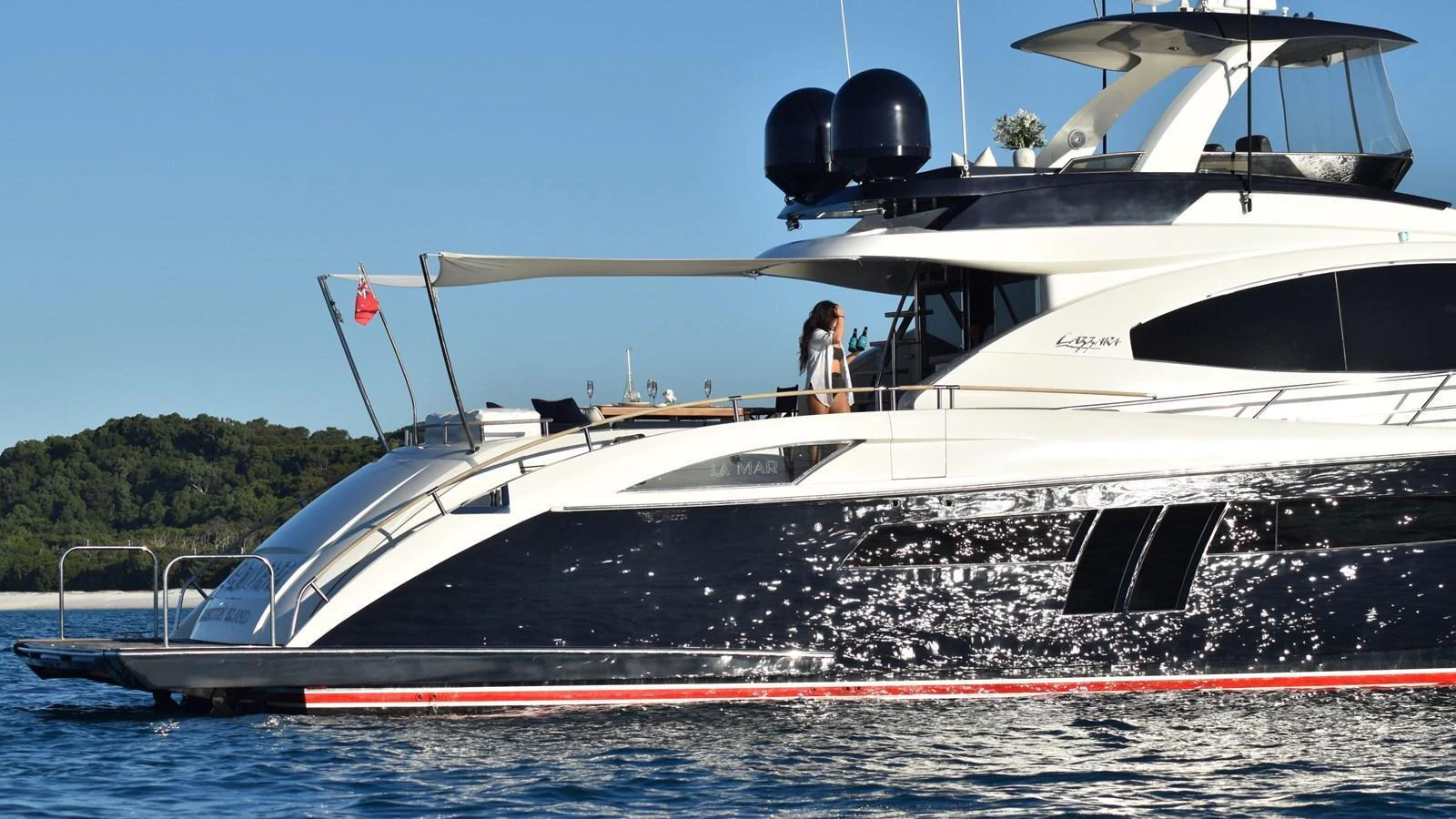 A sleek and modern yacht cruising on calm waters with a scenic backdrop. aboard LA MAR Yacht for Sale