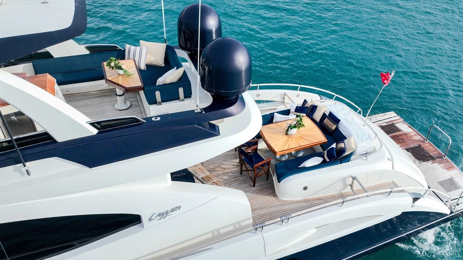 The yacht's aft deck features a stylish seating area with a dining table, perfect for alfresco dining and relaxation. aboard LA MAR Yacht for Sale