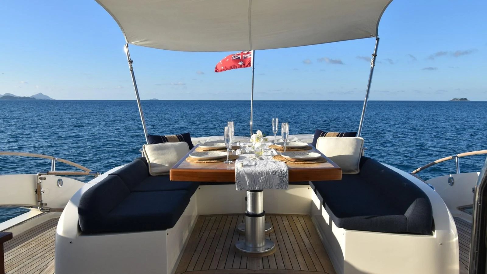 The aft deck features an elegant dining area with a stunning ocean view. aboard LA MAR Yacht for Sale