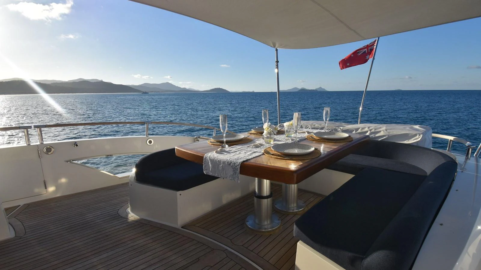 The aft deck features a stylish dining area with a beautiful ocean view. aboard LA MAR Yacht for Sale