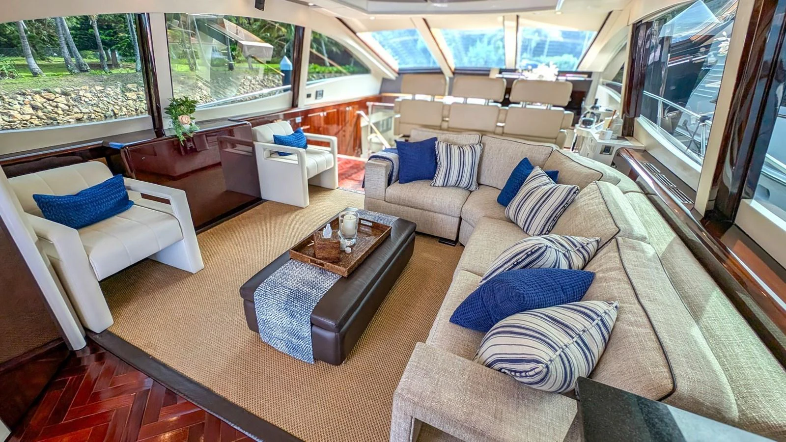 The salon features luxurious seating with plush cushions and panoramic windows offering stunning views. aboard LA MAR Yacht for Sale