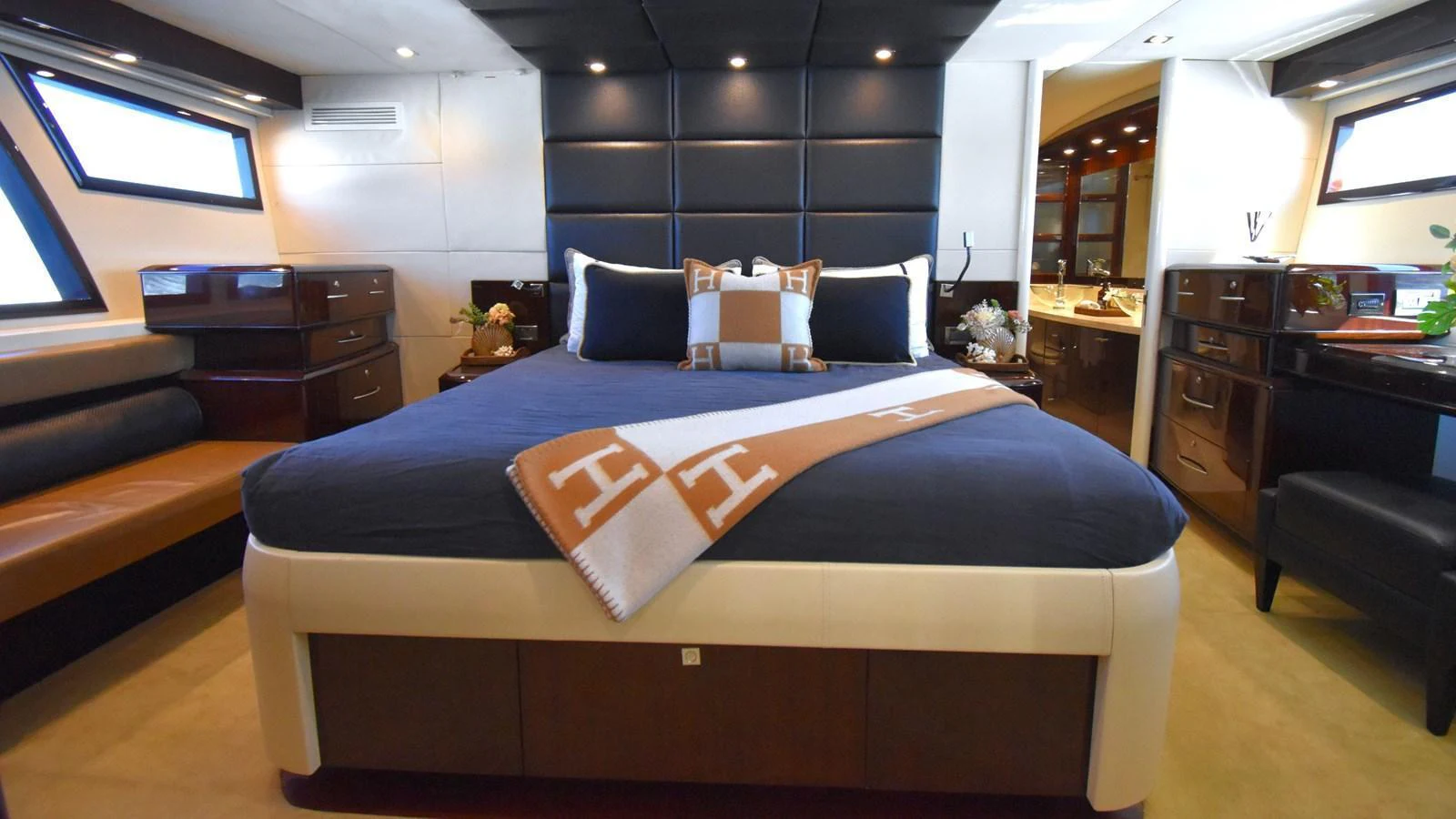 The master stateroom features a luxurious bed with elegant decor and ample natural light. aboard LA MAR Yacht for Sale
