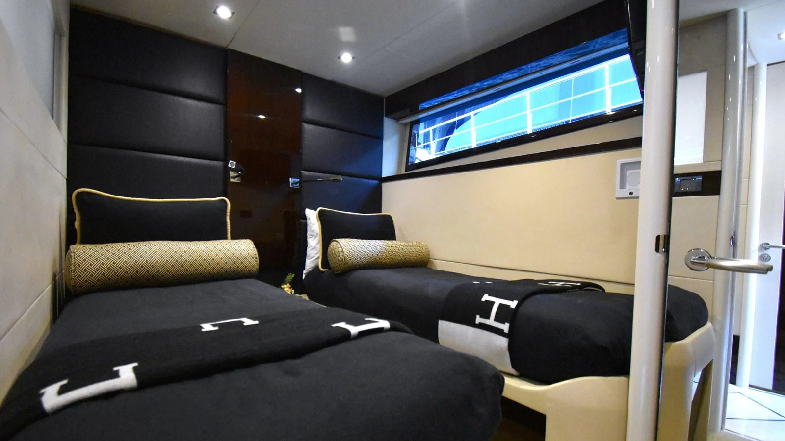 The guest stateroom features twin beds with elegant black and gold accents, providing a comfortable and stylish retreat. aboard LA MAR Yacht for Sale