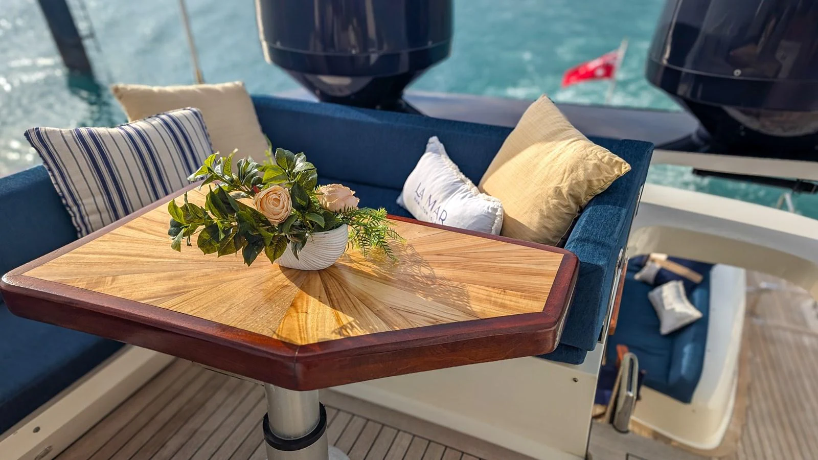 A cozy outdoor seating area with a wooden table and plush cushions, perfect for relaxation. aboard LA MAR Yacht for Sale