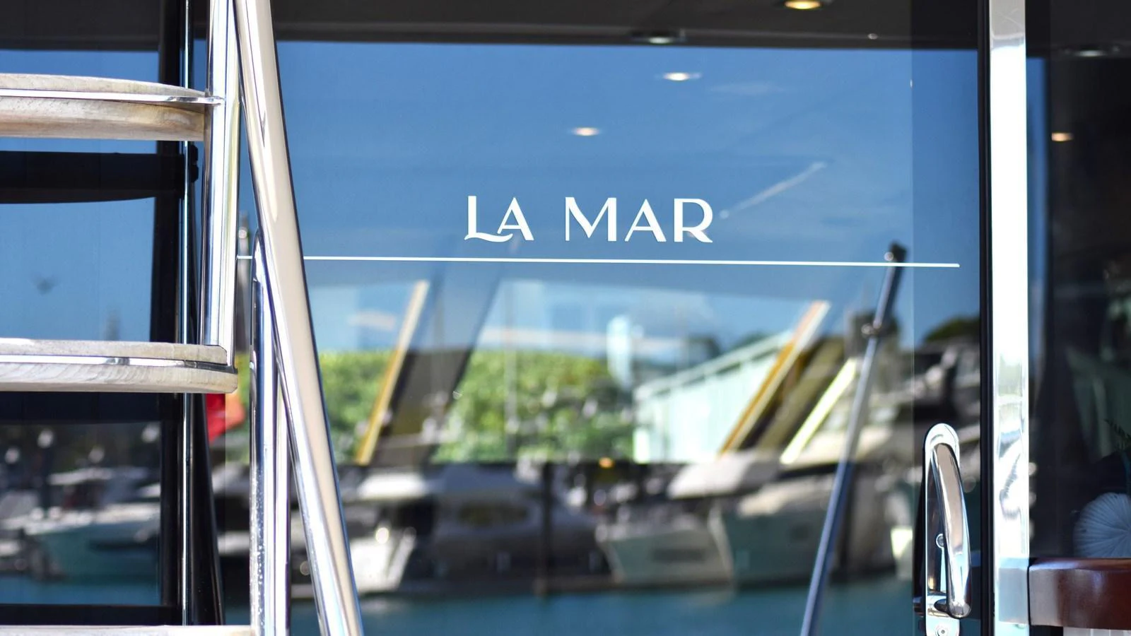 A close-up view of the yacht's name displayed on a reflective glass surface. aboard LA MAR Yacht for Sale