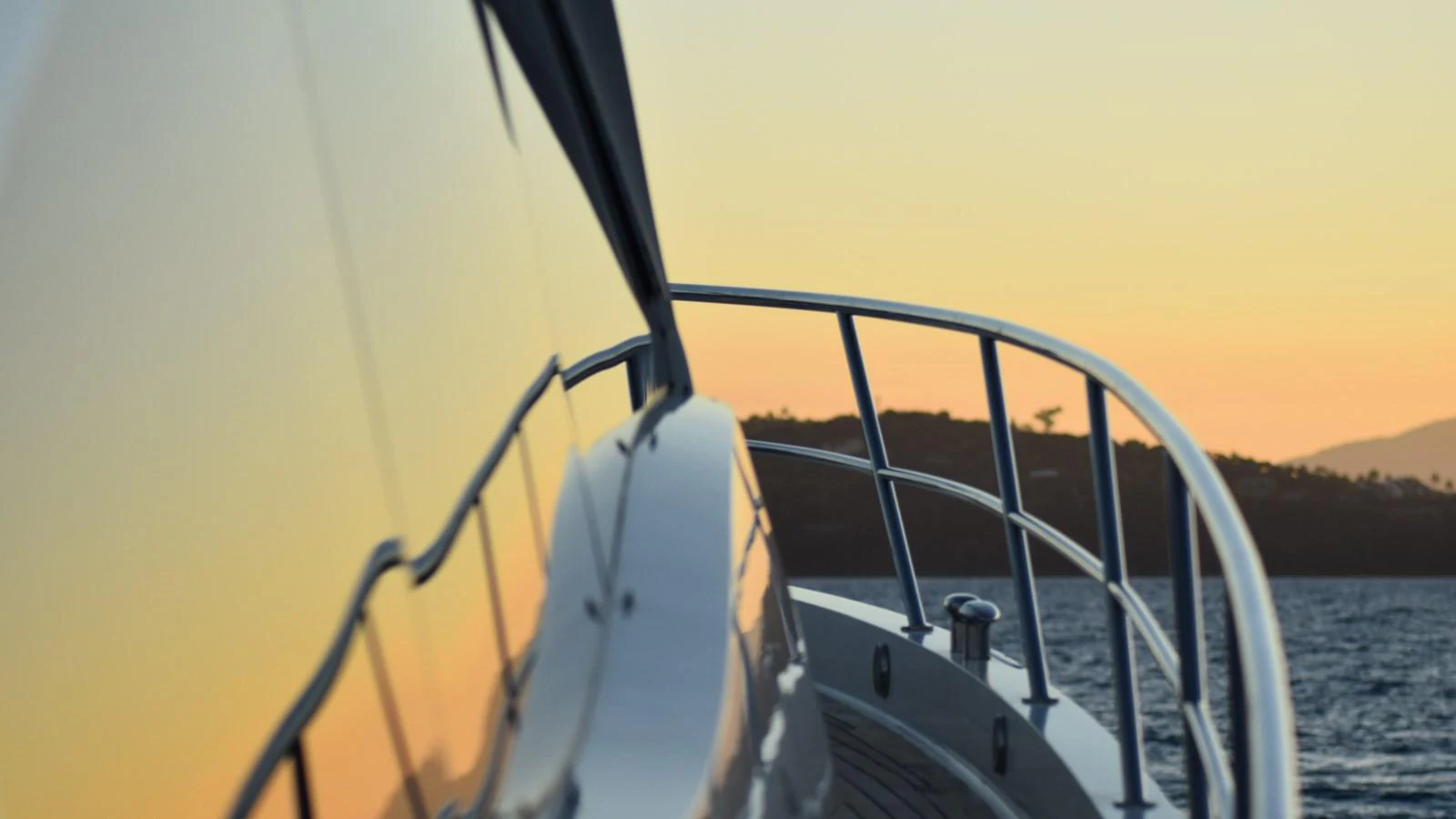 A close-up view of the yacht's railing and deck at sunset, reflecting the serene surroundings. aboard LA MAR Yacht for Sale