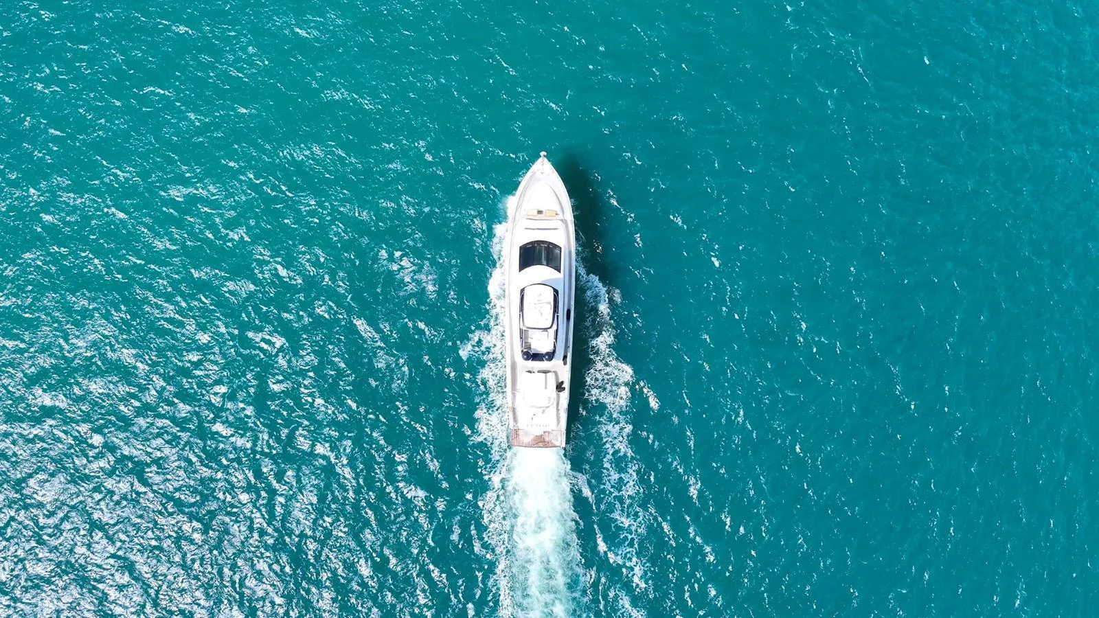 Aerial view of a sleek yacht cruising through clear blue waters. aboard LA MAR Yacht for Sale