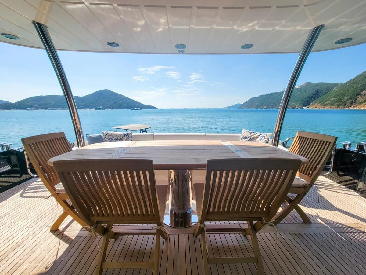 a table and chairs on a deck overlooking a body of water aboard 2008 SUNSEEKER 90  @ ACAPULCO Yacht for Sale