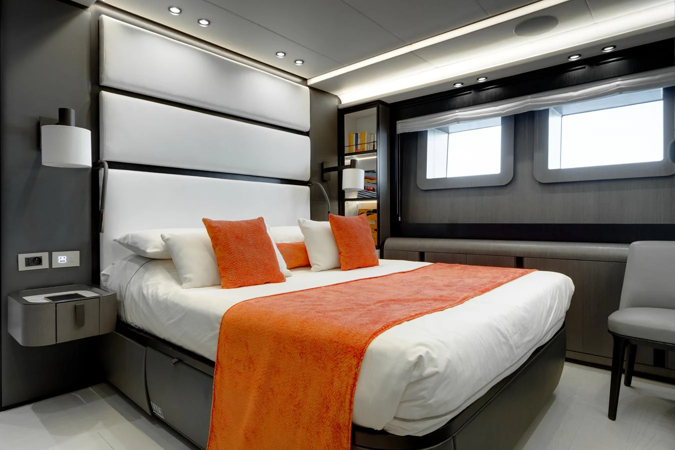 A luxurious stateroom featuring a large bed with orange accents and modern lighting. aboard L.A.U.L. Yacht for Sale