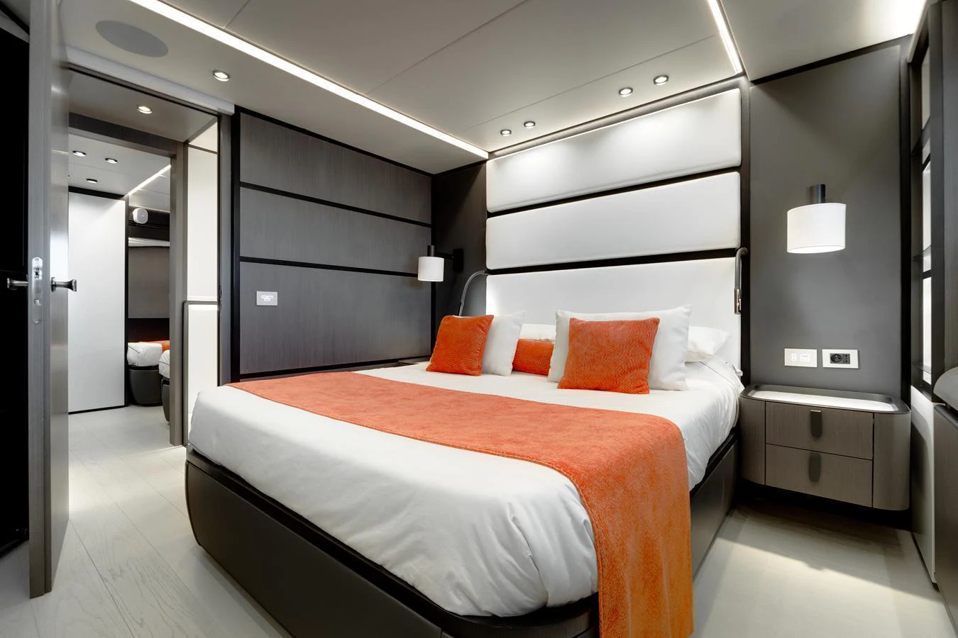 A luxurious stateroom featuring a large bed with orange accents and modern lighting. aboard L.A.U.L. Yacht for Sale