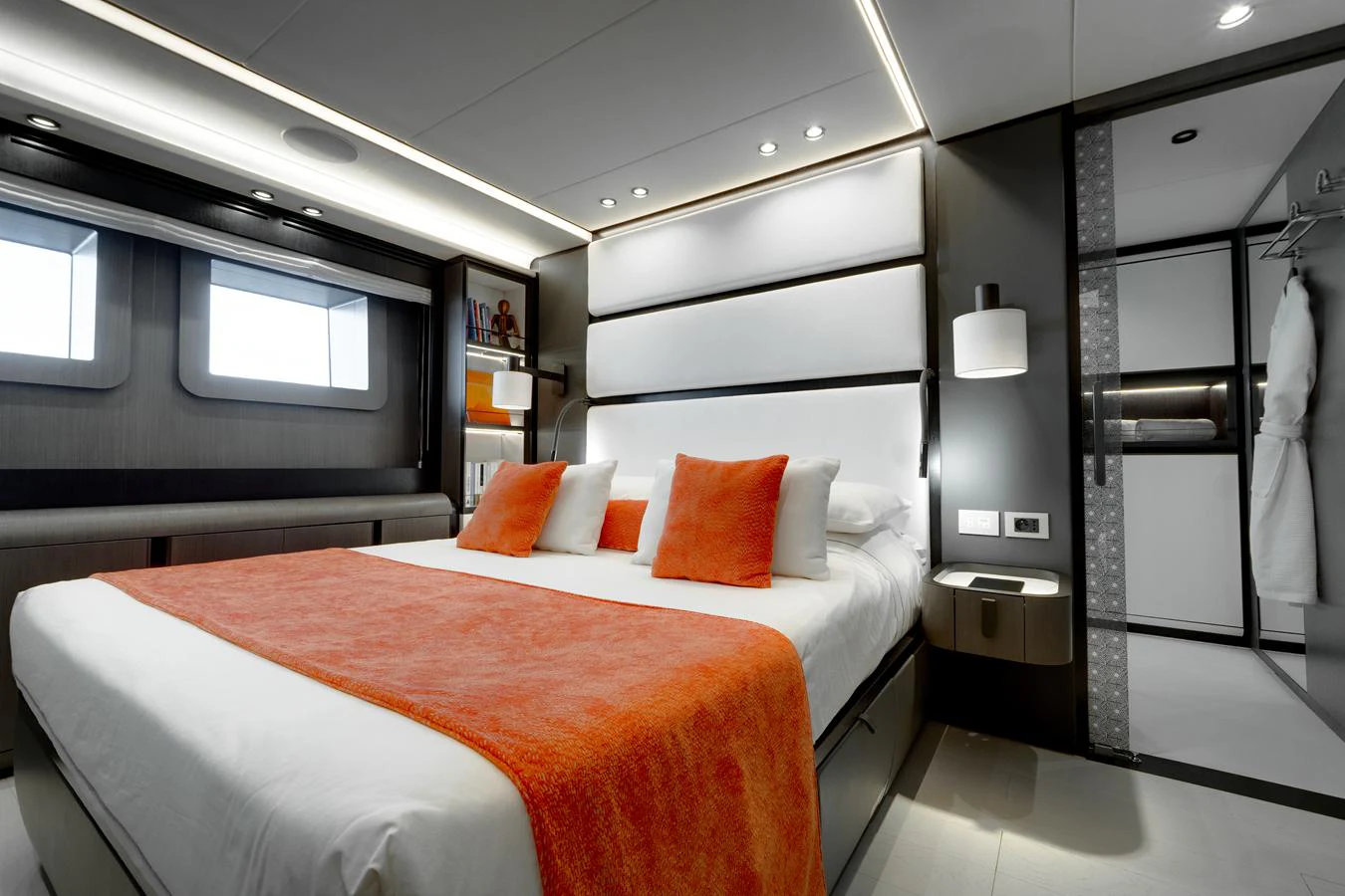 The stateroom features a luxurious bed with vibrant orange accents and modern decor. aboard L.A.U.L. Yacht for Sale