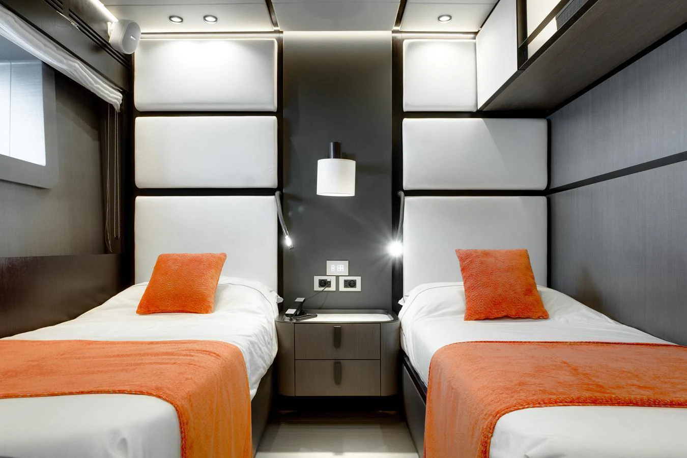 The guest stateroom features twin beds with vibrant orange accents and modern lighting. aboard L.A.U.L. Yacht for Sale