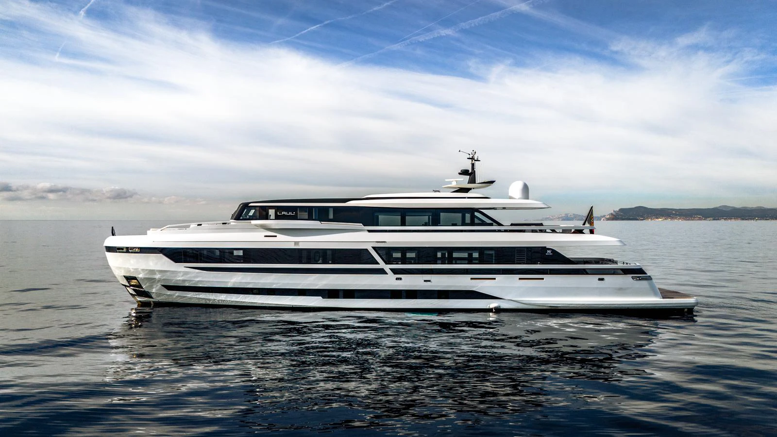 A sleek and modern yacht glides gracefully on calm waters under a partly cloudy sky. aboard L.A.U.L. Yacht for Sale