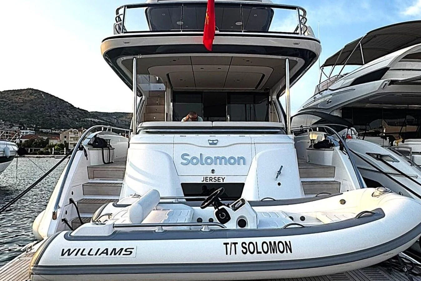 a white boat with a red stripe aboard SOLOMON Yacht for Sale