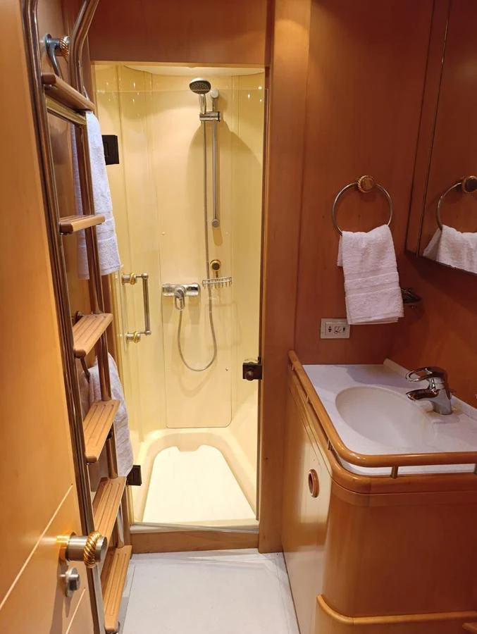 A compact and well-appointed yacht bathroom with a shower and sink. aboard PERSISTENCE Yacht for Sale