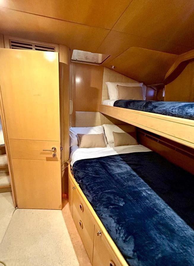 The cozy guest cabin features bunk beds with plush bedding and ample storage space. aboard PERSISTENCE Yacht for Sale