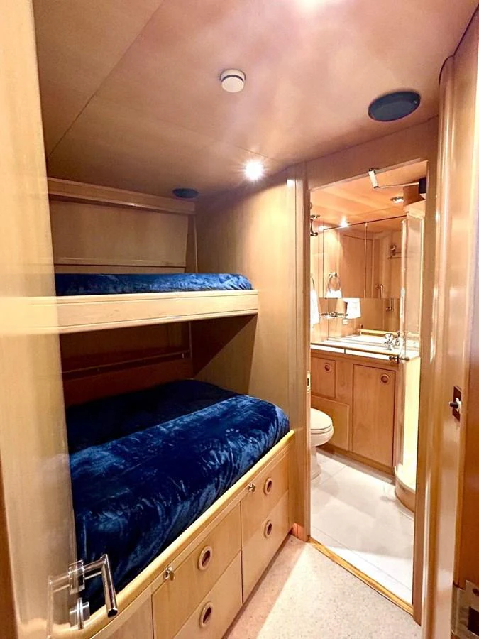 The cozy guest cabin features bunk beds with plush blue bedding and an ensuite bathroom. aboard PERSISTENCE Yacht for Sale
