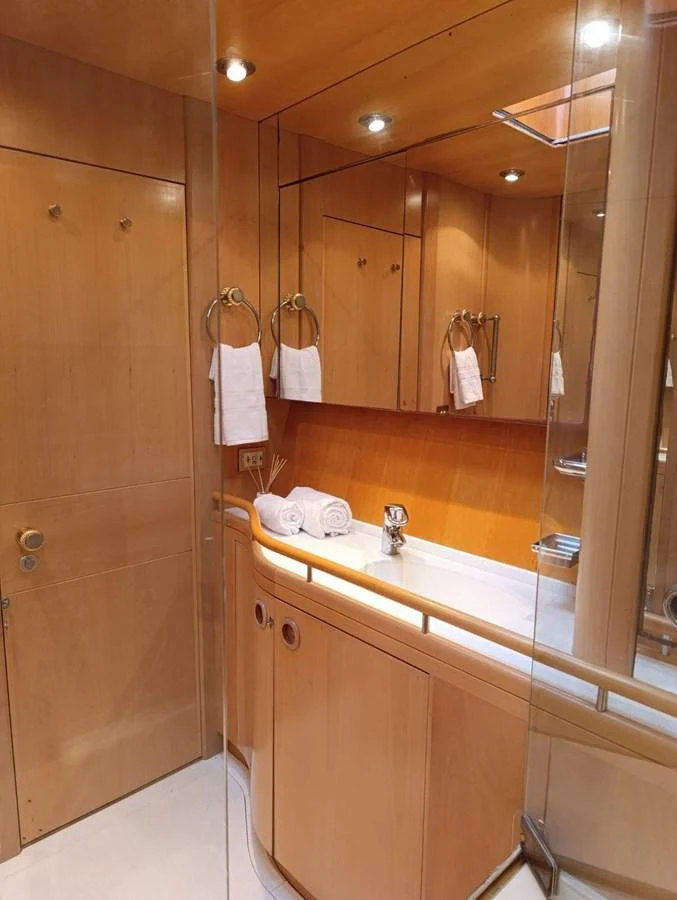 The yacht's bathroom features elegant wood paneling and modern fixtures. aboard PERSISTENCE Yacht for Sale