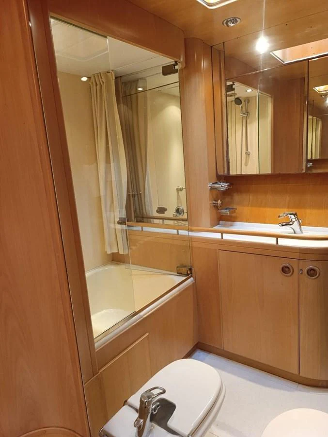 The yacht's bathroom features elegant wood paneling and modern fixtures. aboard PERSISTENCE Yacht for Sale