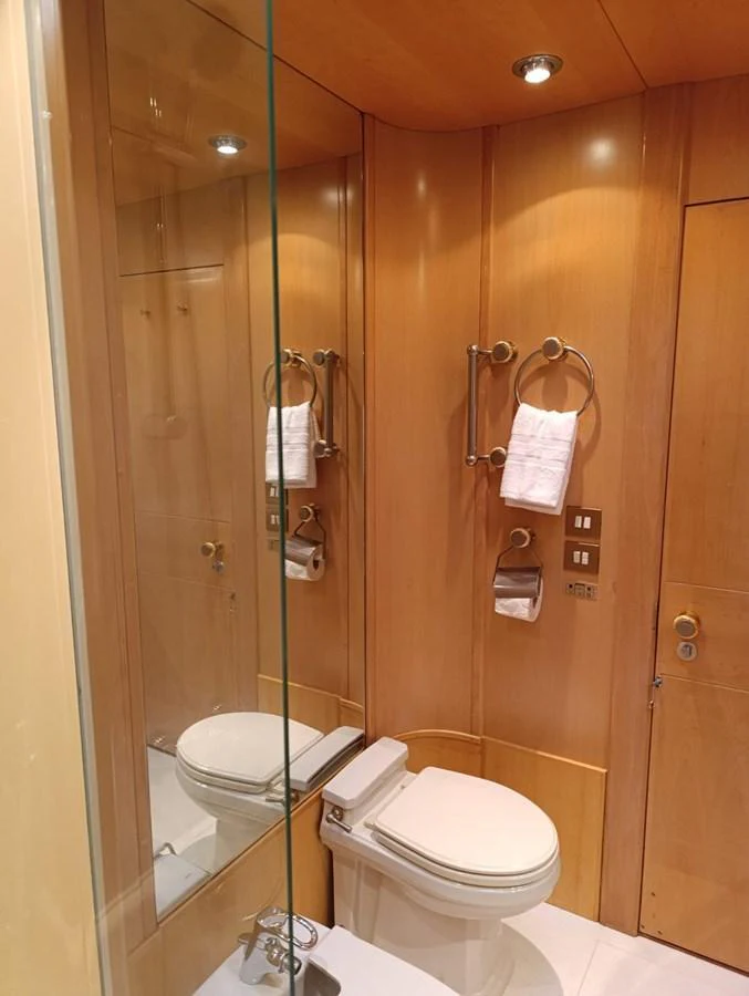A sleek and modern yacht bathroom with wooden paneling and elegant fixtures. aboard PERSISTENCE Yacht for Sale