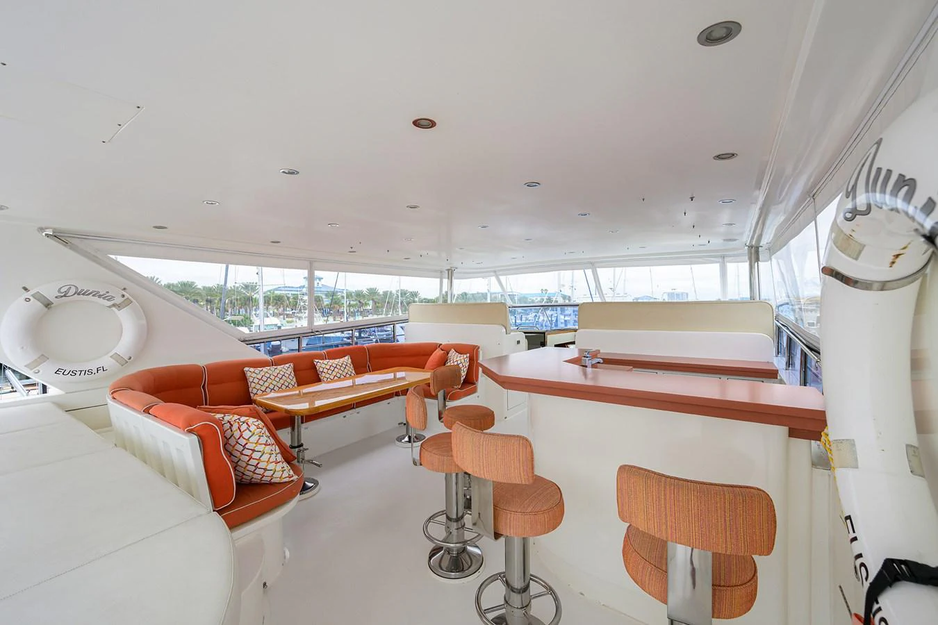 a room with orange couches and a white table aboard DUNIA Yacht for Sale