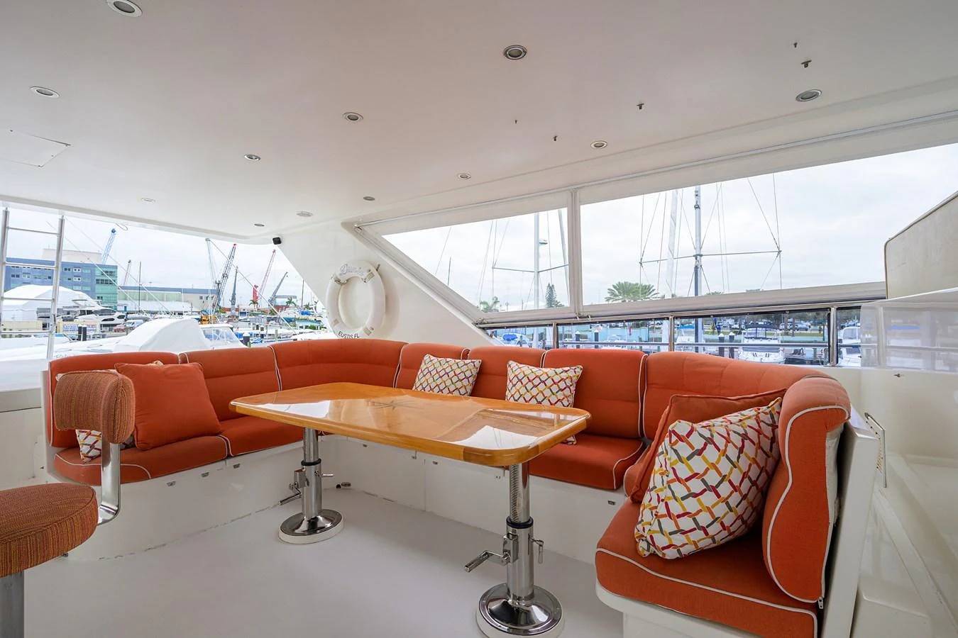 a room with orange couches and a table with a yellow table aboard DUNIA Yacht for Sale
