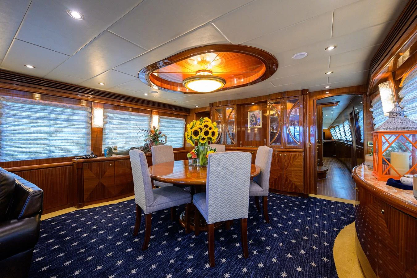 a room with a table chairs and a blue rug aboard DUNIA Yacht for Sale