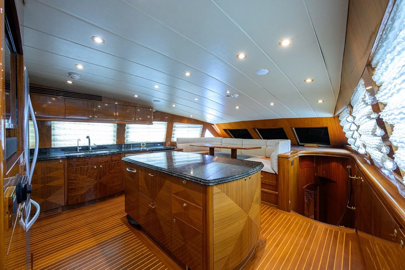 a room with a bar and a table aboard DUNIA Yacht for Sale