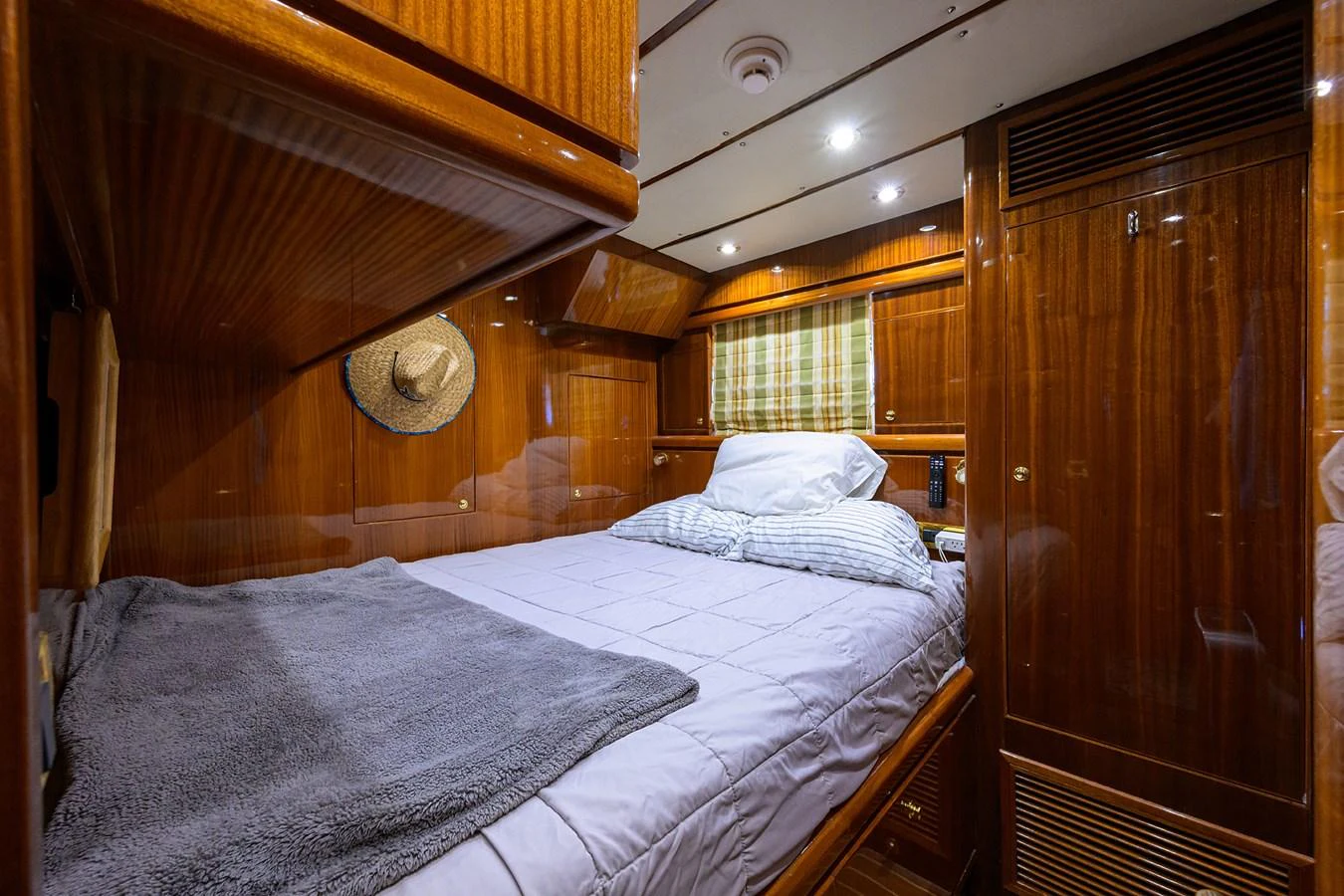 a bed with a wooden headboard aboard DUNIA Yacht for Sale