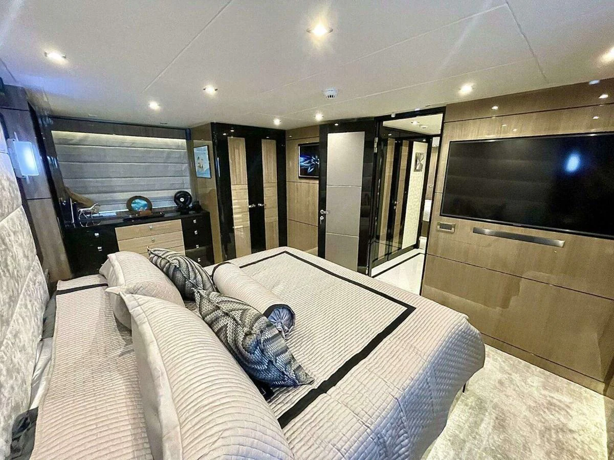 a bedroom with a bed and a dresser aboard SCORPIO II Yacht for Sale