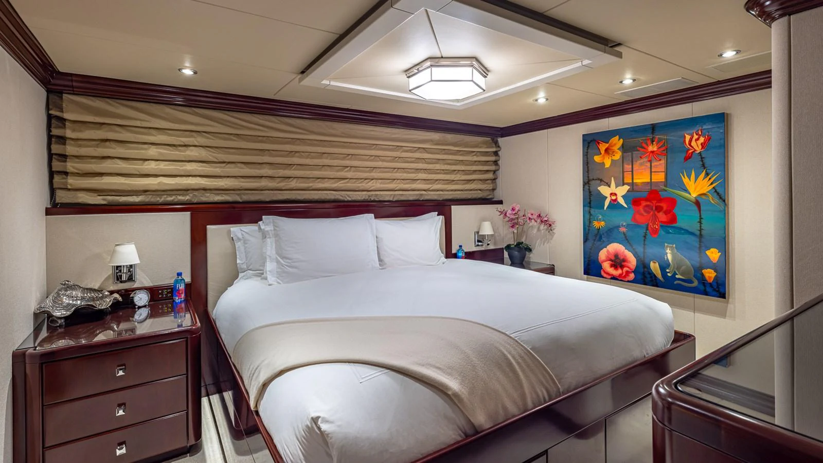 a bed with a painting on the wall aboard LADY JOY Yacht for Sale