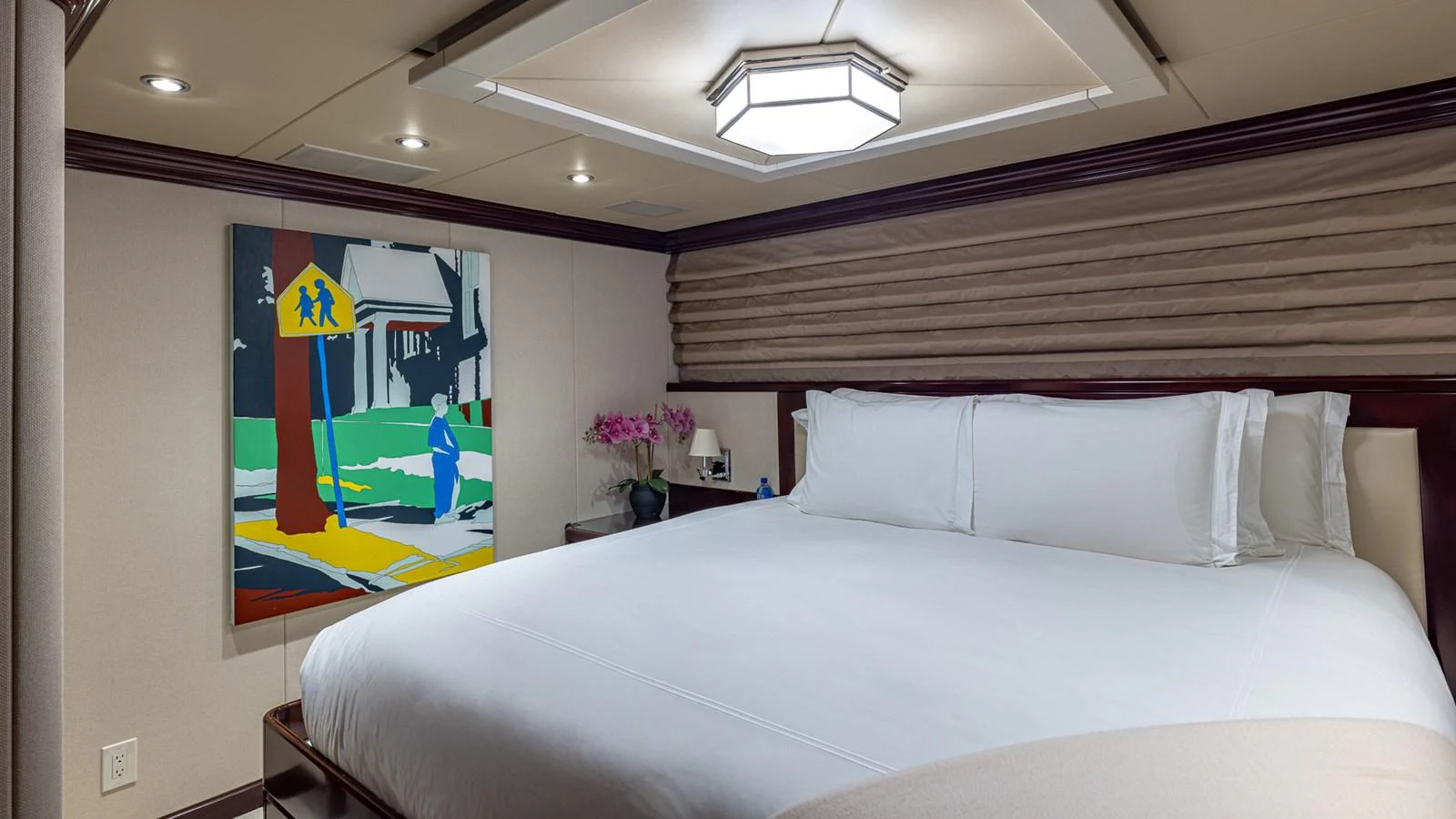 a bed with a painting on the wall aboard LADY JOY Yacht for Sale