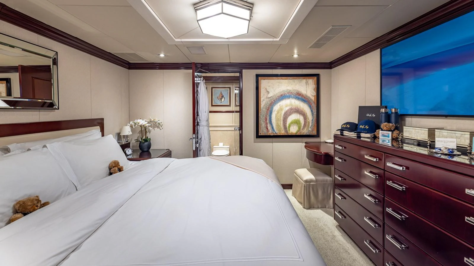 a bedroom with a bed and a dresser aboard LADY JOY Yacht for Sale