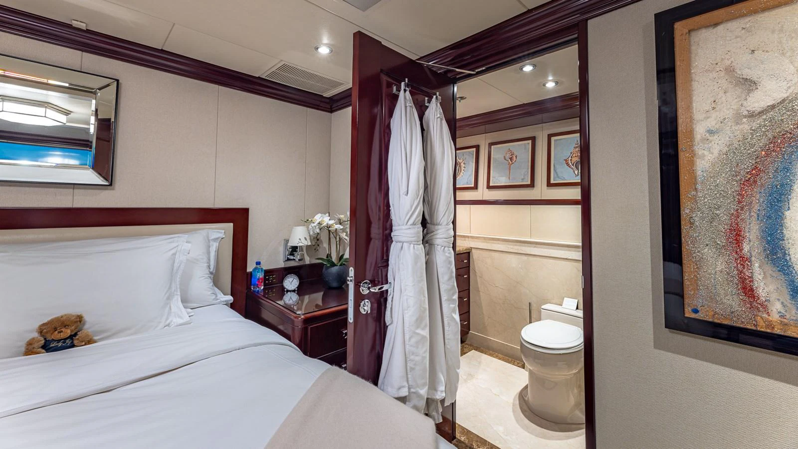 a bedroom with a bed and a mirror aboard LADY JOY Yacht for Sale