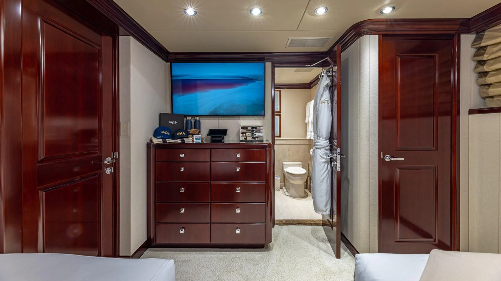 a bathroom with a tv and a closet aboard LADY JOY Yacht for Sale