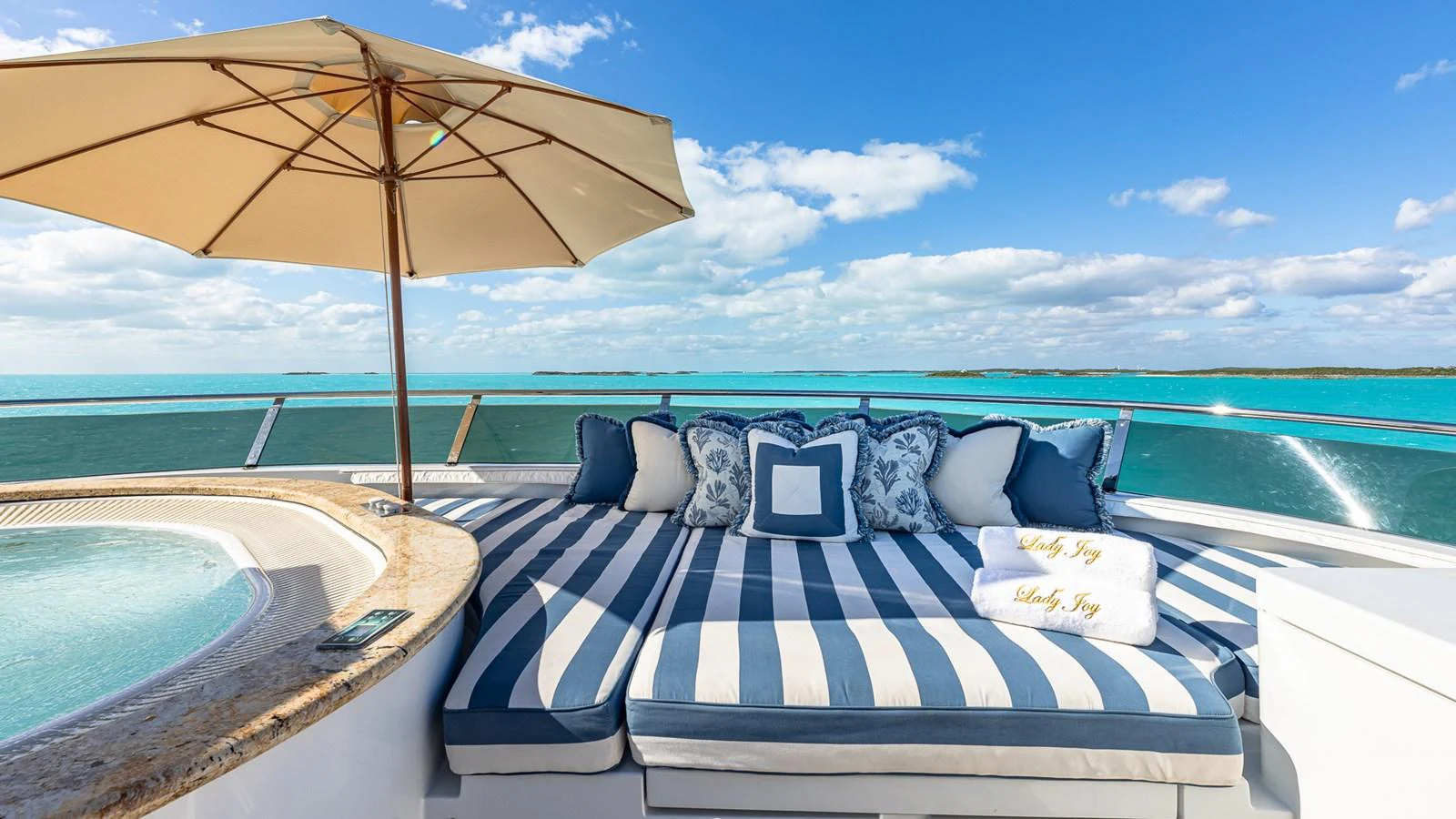 a lounge chair and umbrella on a beach aboard LADY JOY Yacht for Sale