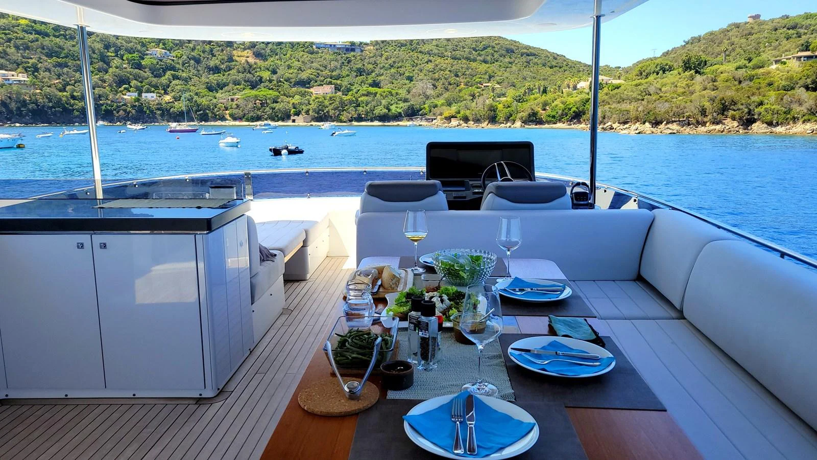 a table with plates and glasses on it by a body of water aboard ARGA Yacht for Sale