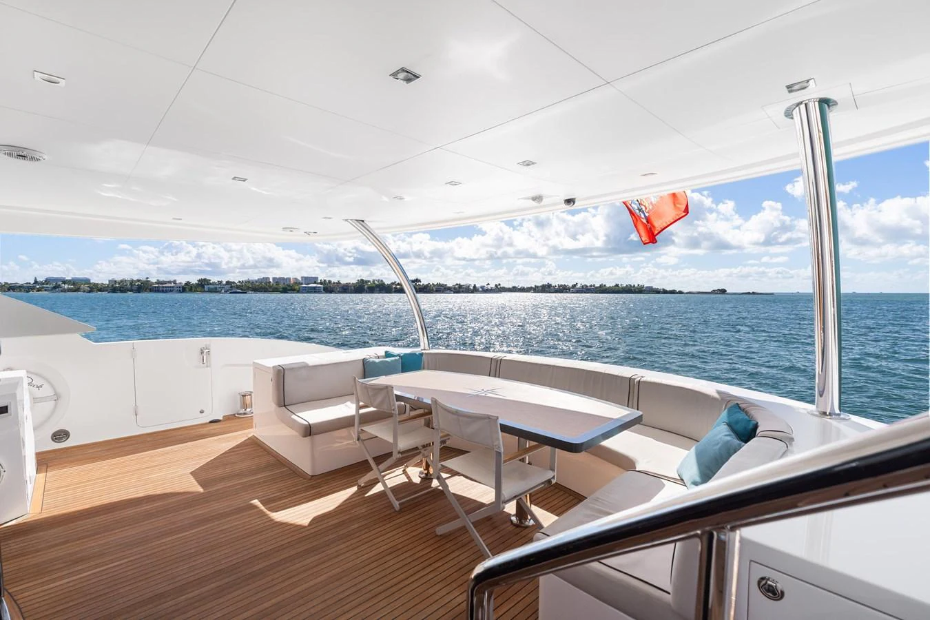 a deck with chairs and a table on it by the water aboard WILD DUCK Yacht for Sale