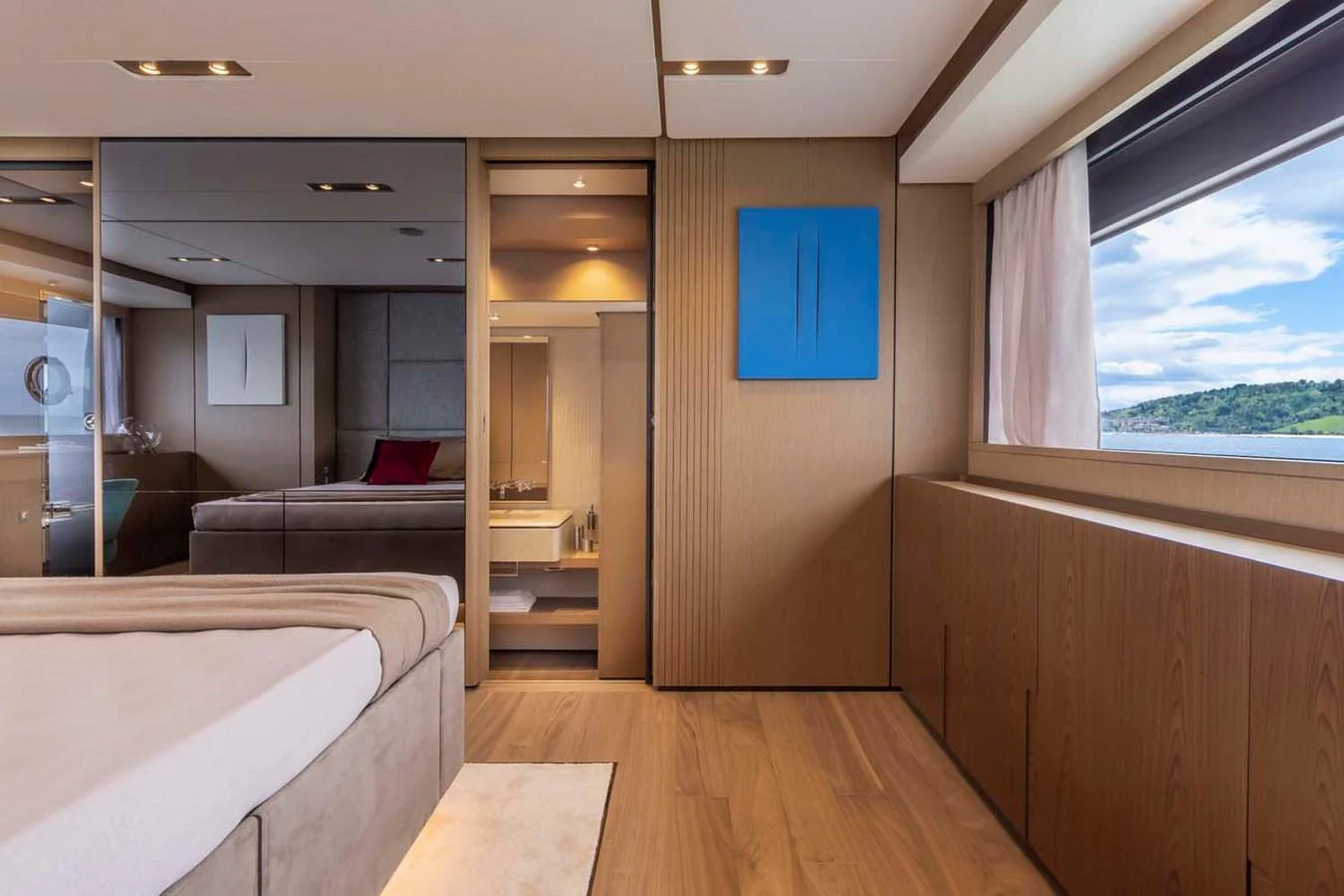 The stateroom features elegant wood paneling, a large window with a scenic view, and contemporary decor. aboard EPIC Yacht for Sale
